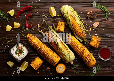 Gegrillter Mais auf dem Kolben auf Küchentisch flach gelegt Hintergrund Stockfoto