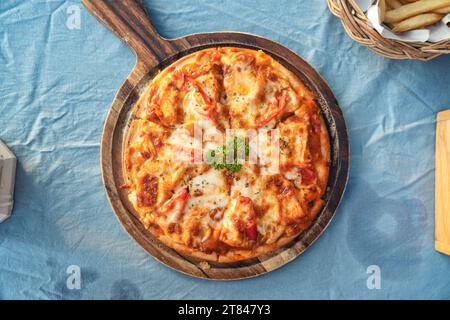 Hausgemachte Hähnchenschinken, Käse, Grillpizza mit Chili, serviert auf Holztablett im italienischen Restaurant Stockfoto