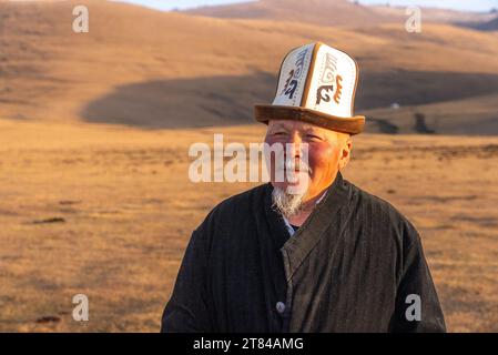 Jurten lagern auf dem Song Kul-See in Kirgisistan, ein einheimischer Mann in traditioneller Kleidung Stockfoto