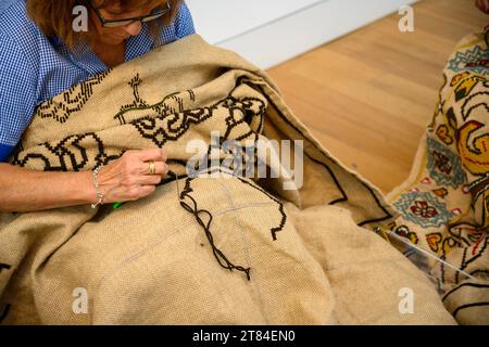 Frau stickt Wandteppiche in traditioneller Weise und entwirft im Wandteppiemuseum in Arraiolos, Portugal einen Teppich Arraiolos, Wandteppiche Arraiolos, AR Stockfoto