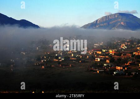 Während die Welt gegen den Klimawandel kämpft, bedeckt Nebel das Dorf Maja am Rande des Drakensbergs in Limpopo, Südafrika als Wettermuster Stockfoto