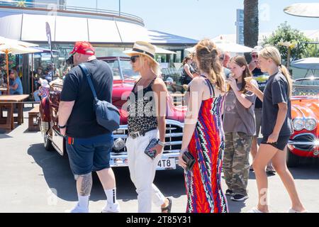 Mount Maunganui Neuseeland - 12. November 2023; Menschen gehen vorbei am alten roten Pontiac Stockfoto