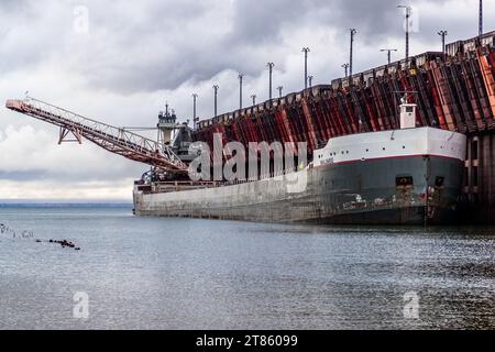 Eisenerz aus dem Tagebau Tilden wird mit dem Zug zum Hochseehafen Marquette transportiert und direkt vom Pocket Dock auf Schiffe abgeladen. Das Marquette Ore Dock ist in Betrieb. Marquette, Usa Stockfoto