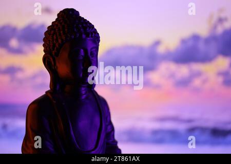 Buddha Purnima und Vesak Tageskonzept, Buddha-Statue mit dezentem Licht vor wunderschönem und farbenfrohen Hintergrund aus nächster Nähe. Meditation Stockfoto