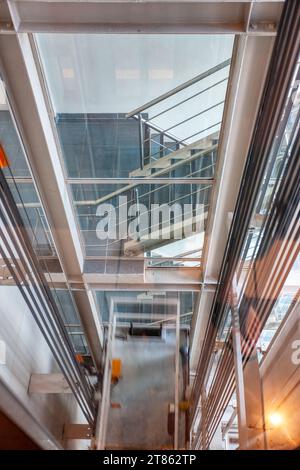 Blick auf den Fahrstuhlschacht nach unten durch das Glas der Treppe Stockfoto