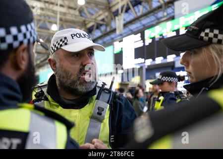 London, Großbritannien. November 2023. Ein Met Police Officer sah, wie er seinen Kollegen am Bahnhof Waterloo verbal befahl. Pro-palästinensische Anhänger versammelten sich am Bahnhof Waterloo zu Sit-in-Protest in Solidarität mit Palästinensern. Es handelt sich um eine Reihe von Sit-in-Protesten, die seit dem Ausbruch des Krieges zwischen Israel und Gaza Anfang Oktober wöchentlich an verschiedenen großen Londoner Bahnhöfen stattfinden. Quelle: SOPA Images Limited/Alamy Live News Stockfoto