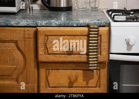 Ein Klebeband mit Muschelhüllen hängt an einer Küchenschublade in der Küche zu Hause, Waffen und Munition, Krieg in der Ukraine Stockfoto