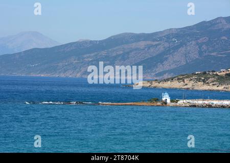 Eine orthodoxe Kirche am Ende einer Anlegestelle in Gialiskari an der Nordküste der griechischen Insel Ikaria, einer „blauen Zone“ in der Ägäis in Griechenland. Stockfoto