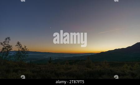 Blick von der Serra da Arada über die Berglandschaft bei Abenddämmerung mit Mondsichel, Sao Pedro do Sul, Portugal Stockfoto