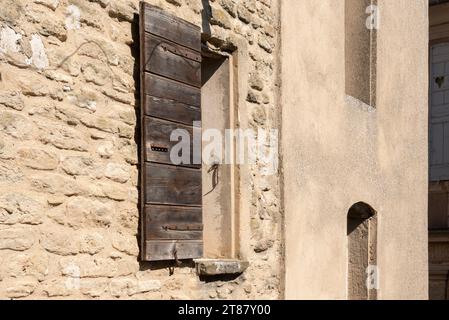 Alte historische Braun- und Beige-Steinhäuser in Gordes, Frankreich, mit verwundeten Fensterläden Stockfoto