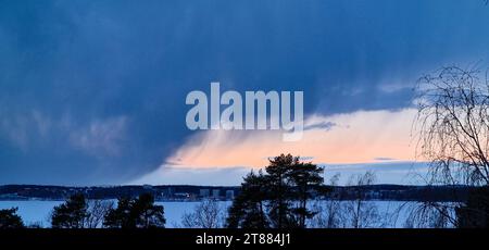 Schneewolken über einem See in Tampere, Finnland Anfang März 2023. Stockfoto