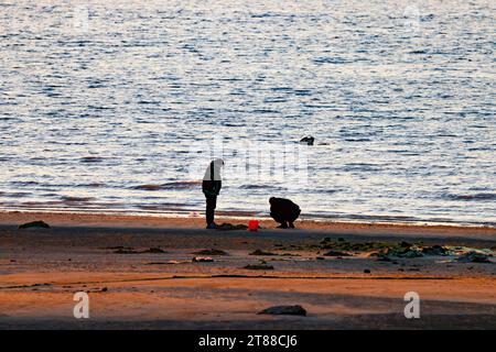 QINGDAO, CHINA - 18. NOVEMBER 2023 - Besucher am Strand der Insel Gujia werden bei Sonnenuntergang in der West Coast New Area von Qingdao, Provinz Shandong, gesehen Stockfoto