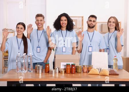 Porträt von Freiwilligen und Lebensmitteln am Tisch drinnen Stockfoto
