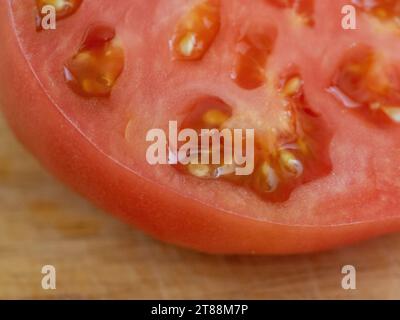Frische Produkte, saftige rote Tomaten in Scheiben mit Fleisch und Samen, die in einem australischen Gemüsegarten angebaut werden Stockfoto