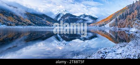 Die Red Mountains, die aus einem frischen Herbstschnee und Wolken am Crystal Lake südlich von Ouray, Colorado, am Million Dollar Highway auftauchen. Stockfoto