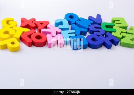 Bunte Buchstaben Bausteine zufällig verstreut auf weißem Hintergrund Stockfoto