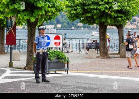 Eine uniformierte Polizistin steht an einer Kreuzung nahe dem Comer See in Bellagio, Lombardei, Italien bereit. Stockfoto