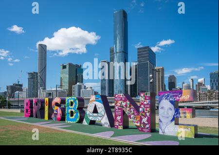 Ein Blick von vor dem „Brisbane“-Schild auf dem South Bank Cultural Presinct an einem Tag mit weißer Wolke und blauem Himmel und den hohen Wolkenkratzern des CBD. Stockfoto