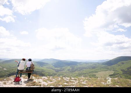 Zwei Personen sitzen auf einer Bank auf einer Bergwandertour in die Natur Stockfoto