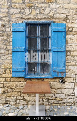 Altes Fenster mit Metallstangen und blauen offenen Rollläden in Limassol. Zypern Stockfoto