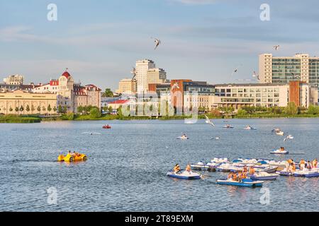 Kasan, Russland - 17. Juni 2023: Menschen auf Tretbooten auf dem Nischni-Kaban-See in der Innenstadt. Aktive Freizeit. Sommerstadt. Stockfoto