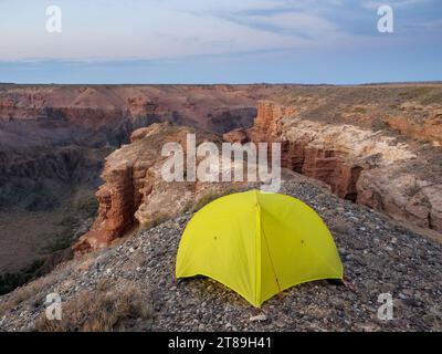 Zelt mit Blick auf den Charyn Canyon. Die roten Gesteinsformationen entstanden durch Erosion über Millionen von Jahren. Eine kleine Nachbildung des Grand Canyon der USA Stockfoto