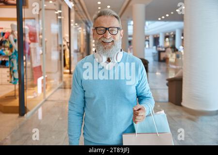 Schöner, eleganter, älterer Mann mit Taschen im Einkaufszentrum Stockfoto