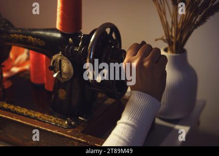 Nahaufnahme einer Frauenhand, die auf einer Nähmaschine Nähte Stockfoto