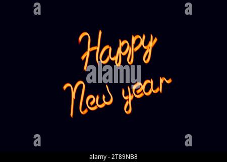 Leuchtend unscharfe orange Inschrift Neujahr auf schwarzem Hintergrund. Vintage-Bild in dunklen Farben Stockfoto