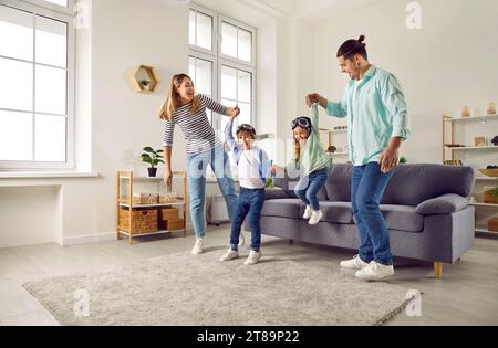 Glückliche junge Familie, die zu Hause im Wohnzimmer spielt Stockfoto