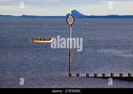 Portobello, Edinburgh, Schottland, Großbritannien. November 2023. Milder Novembermorgen für diejenigen, die sich in der Sonne sportlich betätigen, bei Temperaturen von 12 Grad Celsius. Im Bild: Eastern Amateur Coastal Rowing Club Crew im Firth of Forth mit Berwick Law im Hintergrund. Credit: Scottiscreative/Alamy Live News. Stockfoto