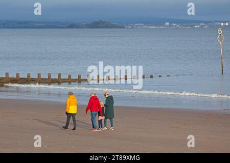 Portobello, Edinburgh, Schottland, Großbritannien. November 2023. Milder Novembermorgen für diejenigen, die sich in der Sonne sportlich betätigen, bei Temperaturen von 12 Grad Celsius. Im Bild: Eine Familie macht einen Spaziergang am Sandstrand am Firth of Forth. Credit: Scottiscreative/Alamy Live News. Stockfoto