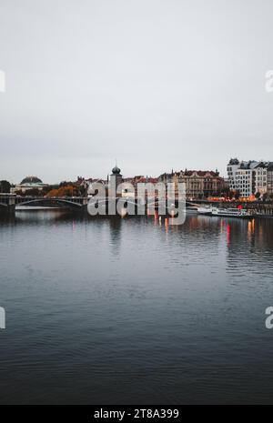 Vertikales Bild des historischen Teils von Prag mit der Moldau im Vordergrund - am Abend aufgenommen. Brücke auf der Moldau im Herbst. Stockfoto