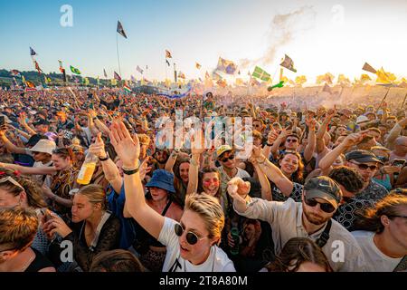 Dateifoto vom 24/06/23, in dem die Zuschauer Fred wieder auf der anderen Bühne beobachten, wie die Sonne über dem Glastonbury Festival auf der Worthy Farm in Somerset untergeht. Die Standardkarten für das Glastonbury Festival 2024 sind in weniger als einer Stunde ausverkauft, haben die Veranstalter bestätigt. Ausgabedatum: Sonntag, 19. November 2023. Stockfoto