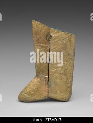 Bronze- und silbergoldene Stiefel, die nach Textil- und Lederstiefeln nachempfunden wurden, wurden in den Gräbern von Liao gefunden. Ein Paar silbergoldene Stiefel (datiert 1018 oder früher) mit phönix-Motiven und Wolkenrollen wurden aus dem Grab von Prinzessin Chen und Xiao Shaoju in der Inneren Mongolei in der Stadt Qinglongshan in Naiman Banner ausgegraben; die Gesichter des Paares waren mit Goldmasken bedeckt. Dieser Stiefel aus vergoldeter Bronze zeigt aufsteigende Drachen, die Perlen jagen, und könnte für einen männlichen Grabbewohner gemacht worden sein. Stiefel aus vergoldeter Bronze, einer von einem Paar, 907–1125. Nordchina, Liao-Dynastie (907–1125). Vergoldete Bronze; 43,2 x 29,2 cm (17 x 11 1/2 Zoll). Stockfoto