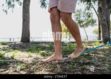 Männliche Füße auf Slackline beim Slacklining im Stadtpark Stockfoto