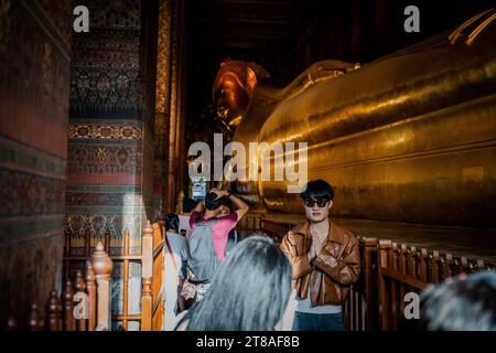 Thailand. November 2023. Ein Tourist lässt sich neben dem liegenden Buddha im Wat Pho im Großen Palast in Bangkok fotografieren. Das tägliche Leben in Bangkok, Thailand, da die thailändische Regierung auf Wachstum im internationalen Tourismusmarkt dringt und kürzlich Programme zur visumfreien Einreise in das Königreich für internationale Touristen aus Russland, China und Indien eingeführt hat. Quelle: Matt Hunt/Neato/Alamy Live News Stockfoto