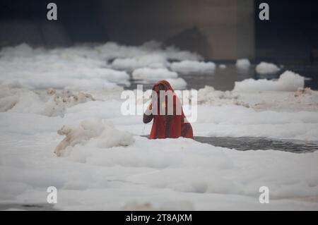 Noida, Indien. Am 19. November 2023 versammeln sich hinduistische Anhänger, um Rituale für den Sonnengott durchzuführen, während sie in den verschmutzten Gewässern des Flusses Yamuna stehen, die mit einer Schicht giftigen Schaum bedeckt sind, anlässlich des Chhath Puja Festivals in Noida am Stadtrand von Neu-Delhi, Indien. Quelle: Anil Shakya/Alamy Live News Stockfoto