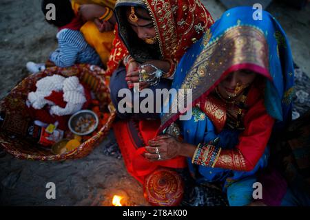 Nepalesische Hindu-Frauen sitzen während des Chhath-Festivals in Kathmandu, während sie die untergehende Sonne am Ufer des Bagmati-Flusses beten. Auf Chhath, einem alten fest, das von Hindus beobachtet wurde, versammeln sich die Gläubigen am heiligen Fluss, um Gebete durch Fasten, Baden und Stehen im Wasser für ununterbrochene Zeiträume zu opfern, um dem Sonnengott zu beten, und danken und Respekt zu erweisen, um Segnungen für das Leben auf Erden zu suchen. Stockfoto