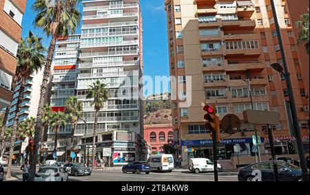 Hochhauswohnungen, Malagueta, Malaga und geschäftige Straßenszene. Werfen Sie einen Blick auf die berühmte Terrakotta-Stierkampfarena und Gibralfaro-Burg zwischen den Gebäuden. Stockfoto