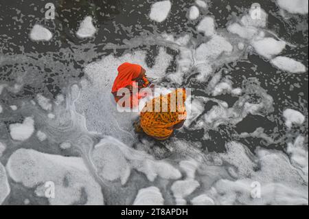 Neu-Delh, Delhi, Indien. November 2023. Hinduistische Gläubige tauchen im Wasser des Yamuna-Flusses inmitten des industriellen Giftschaums ein, während sie den Sonnengott während des Hindu-Festivals von Chhath Puja am 19. November 2023 in Neu-Delhi, Indien, verehren. (Kreditbild: © Kabir Jhangiani/ZUMA Press Wire) NUR REDAKTIONELLE VERWENDUNG! Nicht für kommerzielle ZWECKE! Stockfoto