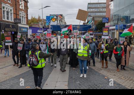 Southend on Sea, Großbritannien. November 2023. Demonstranten marschieren durch die Southend High Street, um Palästina zu unterstützen, und tragen Flaggen und Plakate mit Botschaften wie "Stopp des Völkermordes im Gazastreifen" und "Freies Palästina". Der Protest geht an Geschäften vorbei, darunter auch an River Island. Mit gut sichtbaren Marshals, die die Menge leiten. Pro-palästinensische Anhänger marschieren durch die Southend High Street zu einer Kundgebung, um einen Waffenstillstand in Gaza zu fordern. Penelope Barritt/Alamy Live News Stockfoto