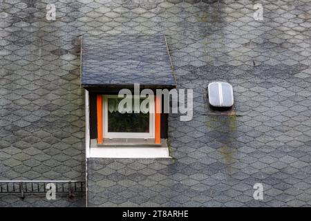 Rechteckiges Zwischengeschoss-Fenster auf dem Dach des Hauses mit flexiblen grauen Fliesen. Von den Fenstern der Welt rechteckiges Zwischengeschoss auf dem Dach Stockfoto