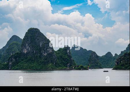 Kleine Fischerboote, in der spektakulären Landschaft der Ha Long Bay, Vietnam. Eines der modernen Naturwunder der Welt. Stockfoto