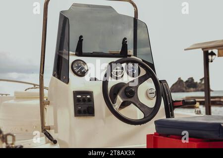 Das Lenkrad einer Segelyacht und ein Navigationsgerät sind weiß und schwarz. Horizontale Aufnahme ohne Personen. Hochwertige Fotos Stockfoto