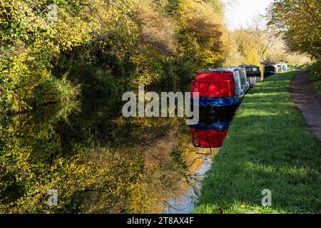 Schmalboote, die im Herbst auf dem Kennet- und Avon-Kanal mit Reflexionen ankern, Monkton Combe, Somerset, England, Großbritannien Stockfoto