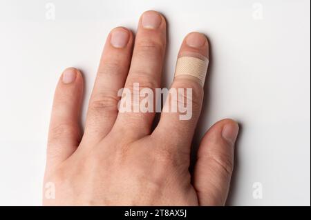 Schnitt bedeckt mit medizinischem Band auf der Hand des Mannes isolierte Nahansicht Stockfoto