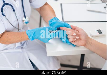 Arzt, der den Blutzuckerspiegel des Patienten mit dem Glukometer misst. Stockfoto