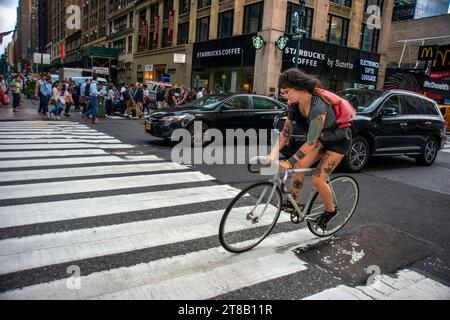 Modefrau mit Tattoos in einem Fahrrad in Manhattan New York USA Stockfoto