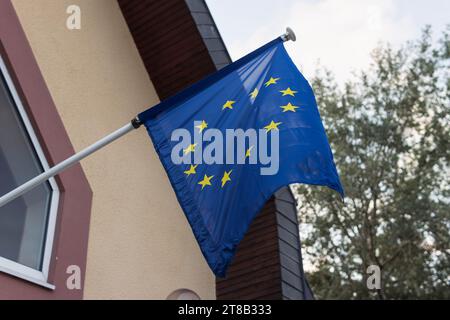 Fahrende EU-Flagge auf der Gebäudewand im Wind flatternde EU-Flagge Stockfoto